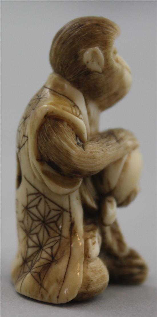 A Japanese ivory netsuke of a seated monkey holding a peach, signed Kogetsu, Meiji period, 3.8cm